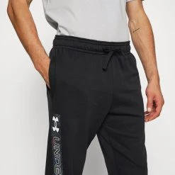 Under Armour RIVAL GRAPHIC JOGGER - Spodnie Treningowe - Black/white -Under Armour shop ef08a411e4fe4a939bb9c91abb783cbb scaled